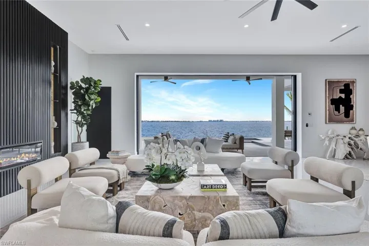 Living room with a water view, ceiling fan, and a healthy amount of sunlight