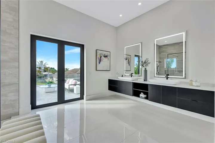 Bathroom featuring french doors, vanity, tile patterned floors, and an enclosed shower