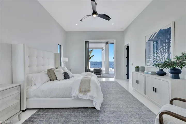 Bedroom with access to outside, a water view, and ceiling fan