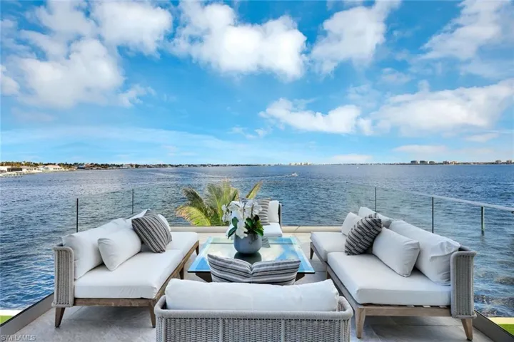 View of patio featuring an outdoor living space, a water view, and a balcony