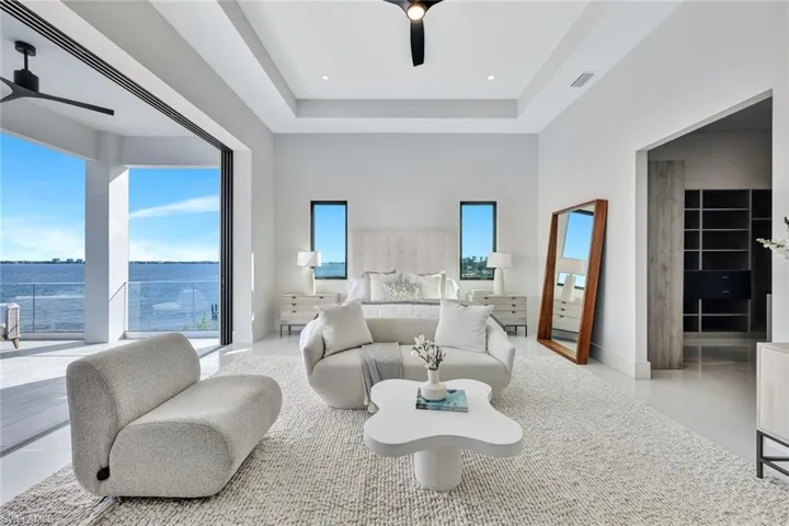 Bedroom featuring multiple windows, ceiling fan, a water view, and a spacious closet