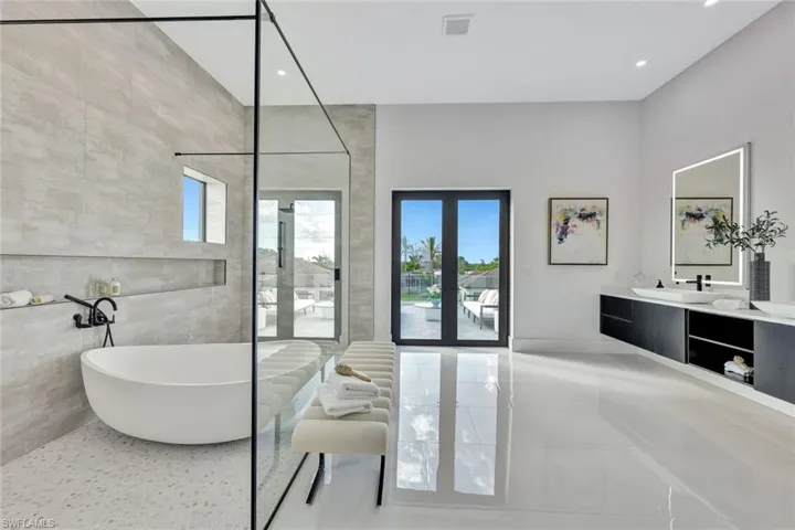 Bathroom featuring tile patterned floors, vanity, and a bath