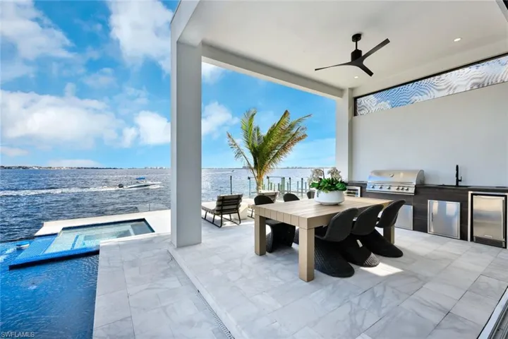 View of patio / terrace featuring sink, a pool with hot tub, grilling area, area for grilling, and a water view