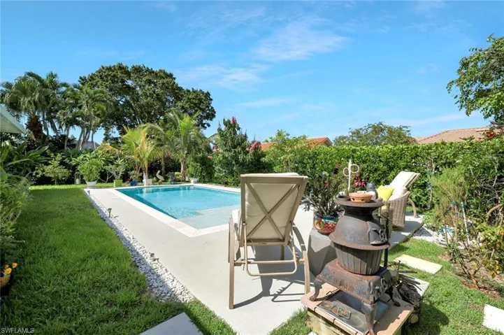 Swimming pool with a patio area and a lawn