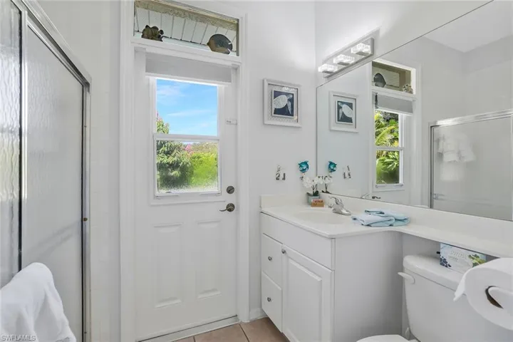 Bathroom featuring a shower stall, vanity, and light tile patterned floors