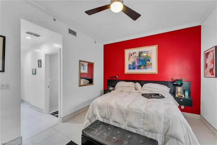 Bedroom with crown molding, light tile patterned floors, and a ceiling fan