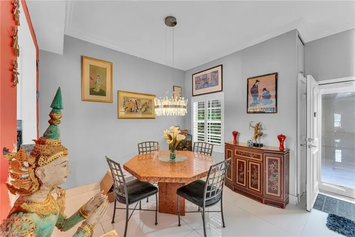 Dining space featuring crown molding and light tile patterned floors