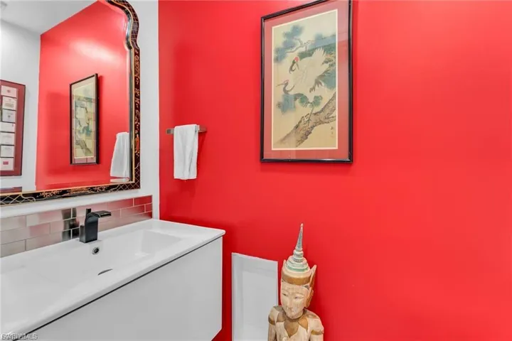 Bathroom featuring vanity and decorative backsplash