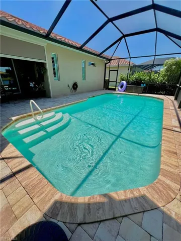 Screened lanai with a large electric heated pool, automated LED pool lighting and brick pavers
