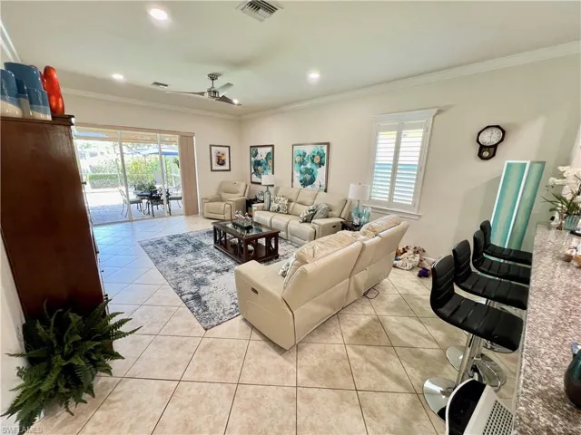 Living room featuring crown molding, recessed LED lighting and high end ceiling fan