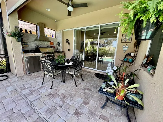 Screened lanai with a built in outdoor kitchen, automatic hurricane shutter and brick pavers