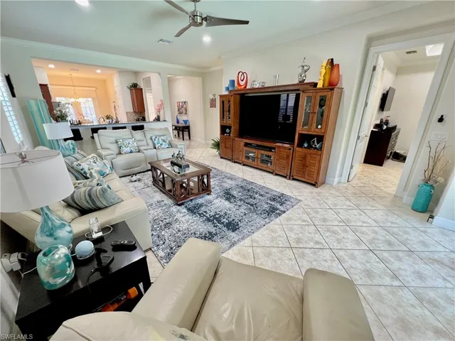 Living room featuring crown molding, recessed LED lighting and high end ceiling fan