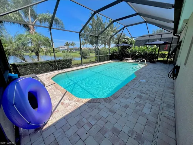 Screened lanai with a large electric heated pool, automated LED pool lighting and brick pavers
