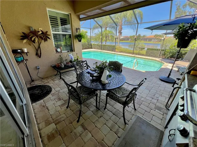 Screened lanai with a built in outdoor kitchen, automatic hurricane shutter, automated LED pool lighting and brick pavers