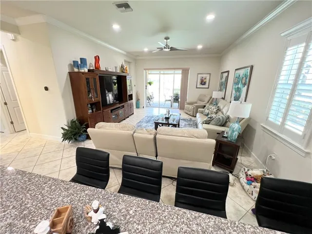 Living room featuring crown molding, recessed LED lighting and high end ceiling fan