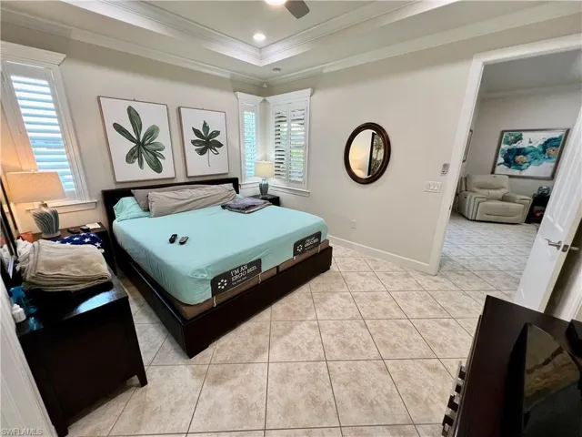 Master bedroom boasting a tray ceiling dressed with crown molding, LED lighting and custom plantation shutters