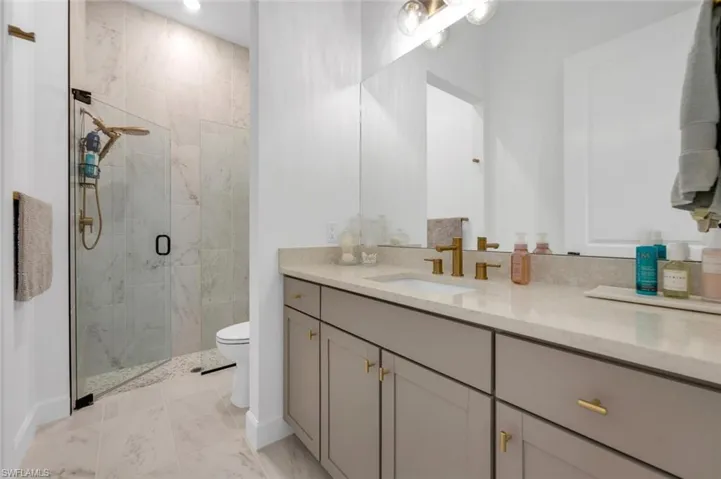 Bathroom with vanity, toilet, and a shower with door
