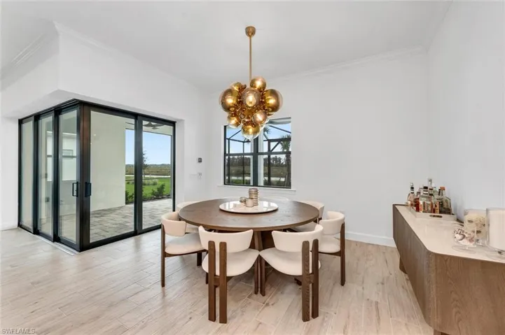 Dining space with crown molding, a notable chandelier, and light hardwood / wood-style floors