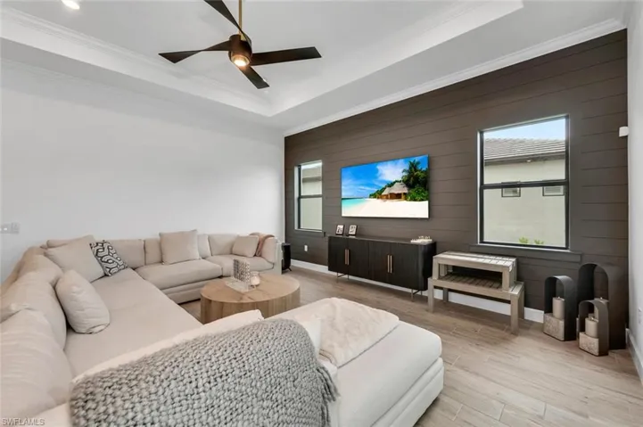 Living room with crown molding, a healthy amount of sunlight, and light wood-type flooring