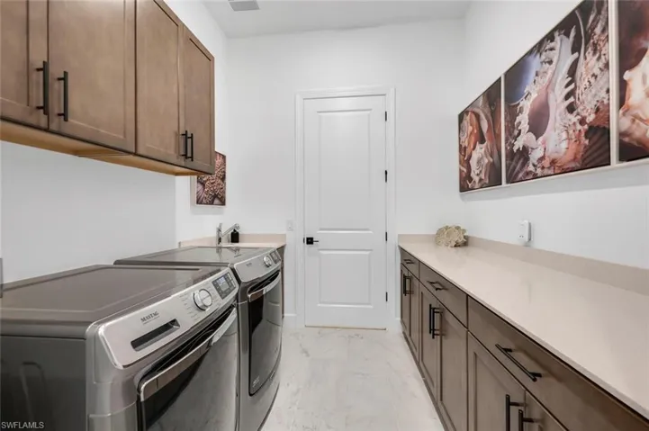 Laundry area featuring cabinets and washer and dryer