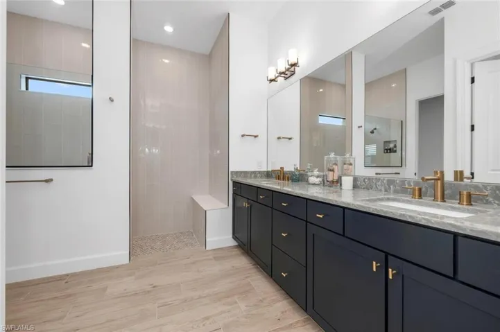 Bathroom with vanity, a tile shower, and hardwood / wood-style flooring