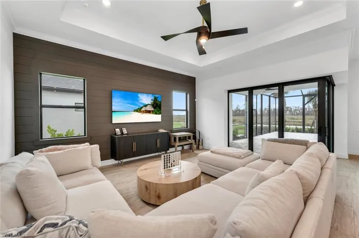 Living room featuring plenty of natural light, light hardwood / wood-style floors, and a raised ceiling