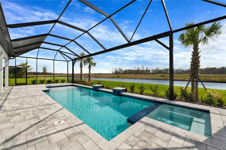 View of swimming pool with a water view, an in ground hot tub, glass enclosure, and a patio