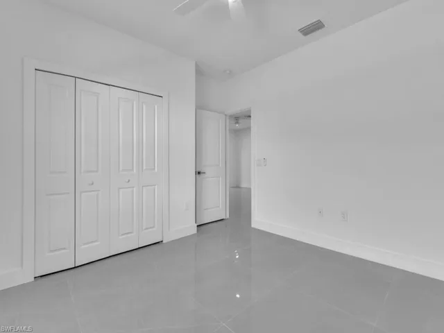 Unfurnished bedroom with light tile patterned floors, a ceiling fan, and a closet