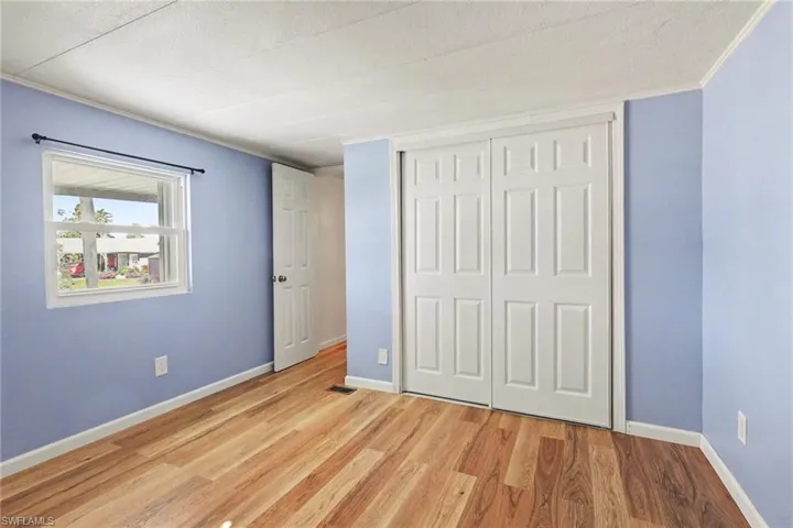 Unfurnished bedroom with light wood finished floors, a closet, and a textured ceiling