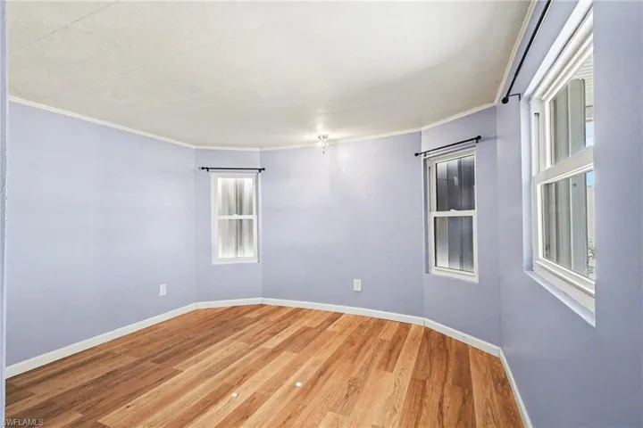 Unfurnished room featuring light wood-style flooring and ornamental molding