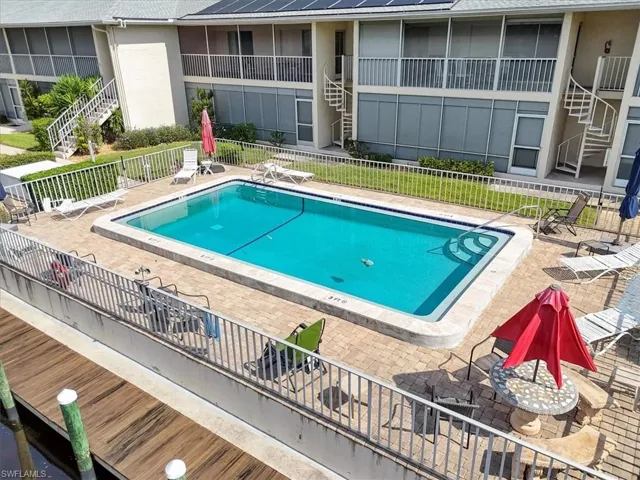 Community pool featuring stairs and a patio
