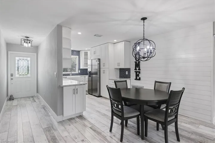 Dining space with light wood finished floors, a chandelier, recessed lighting, and ceiling fan