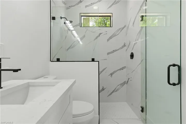 Contemporary bathroom featuring a walk-in shower with clear glass enclosure and matte black hardware