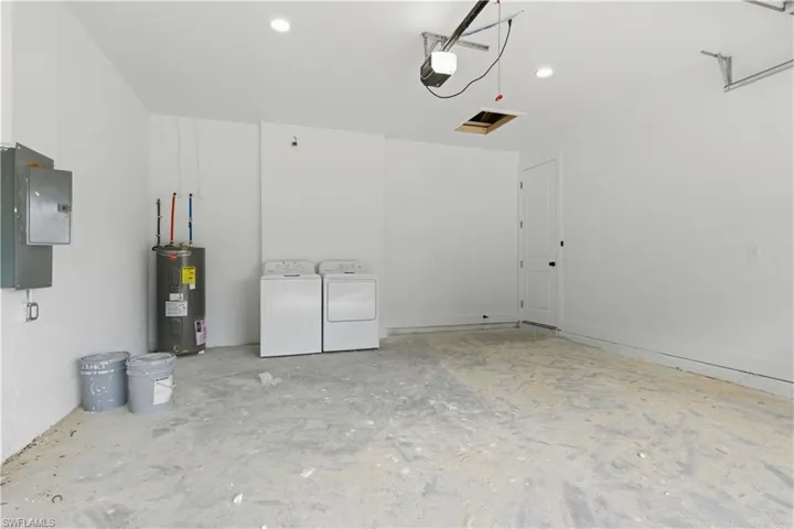 Garage space featuring a water heater and laundry appliances