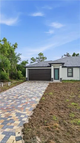 Contemporary single-story residence featuring a paver driveway