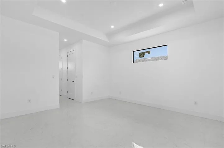 Tiled spare room featuring a tray ceiling
