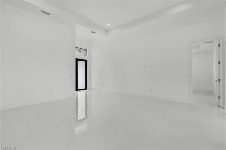 Empty room with a raised ceiling and light tile patterned floors