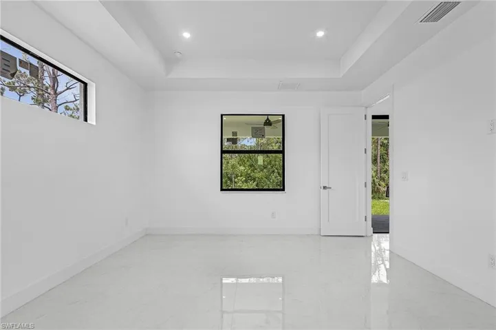 Spare room with light tile patterned floors and a tray ceiling
