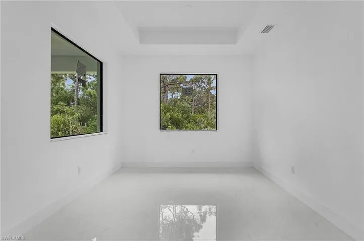 Tiled spare room with a tray ceiling