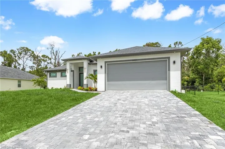 View of front of house featuring a garage and a front yard