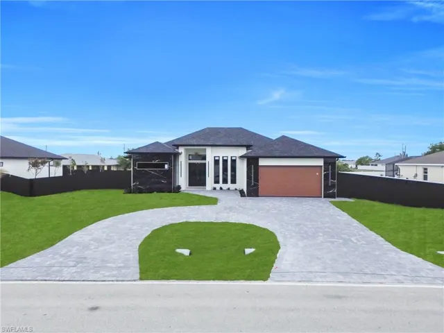 Prairie-style home featuring curved driveway and a garage
