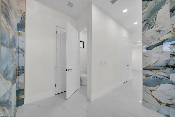 Corridor with recessed lighting and light marble finish flooring