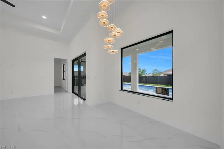 Spare room with a high ceiling, recessed lighting, and light marble finish flooring