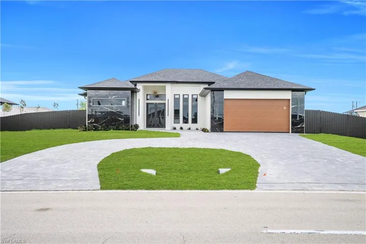 Prairie-style home featuring curved driveway, stucco siding, a shingled roof, french doors, and an attached garage