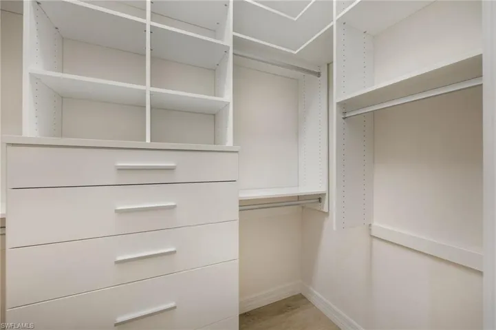 Bathroom featuring a bath, two vanities, a marble finish shower, and light marble finish floors