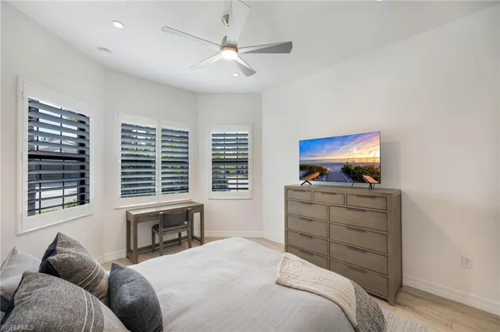 Bedroom with light wood-type flooring, a ceiling fan, and recessed lighting