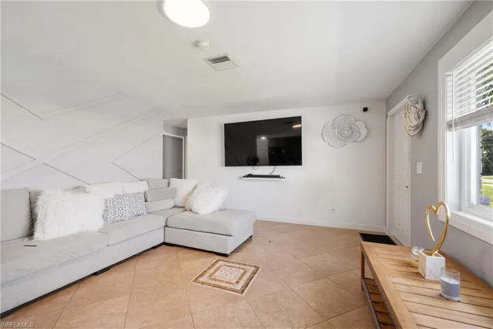 Tiled living room featuring plenty of natural light