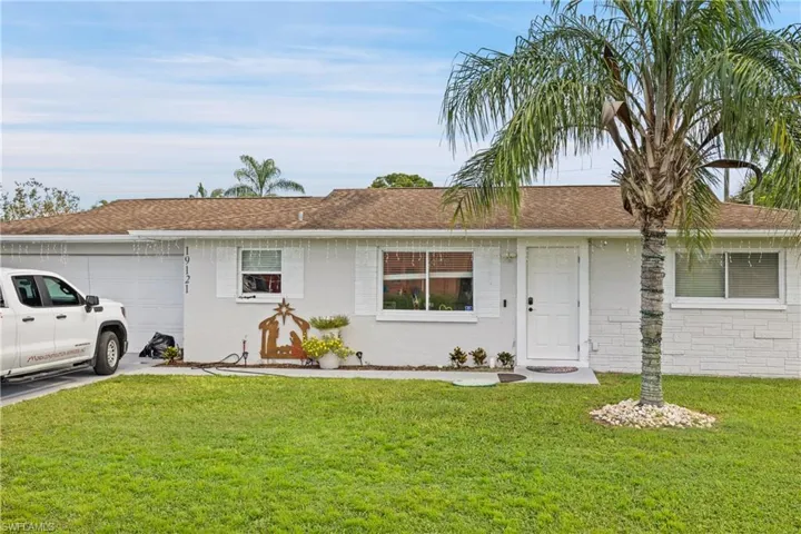 Ranch-style home featuring a garage and a front lawn