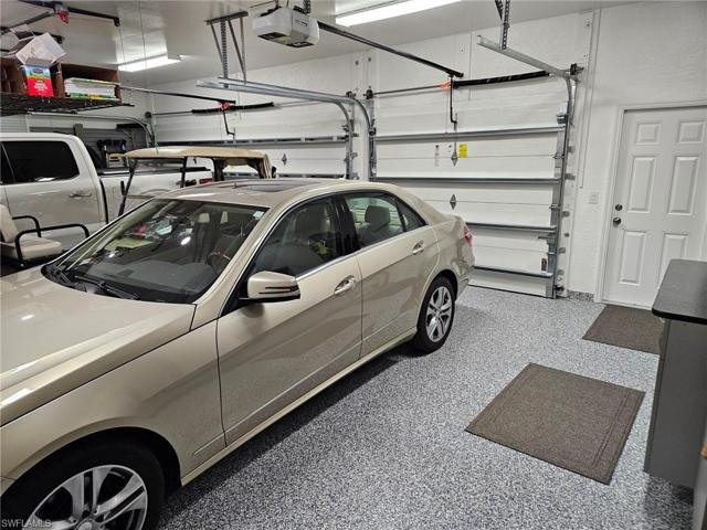 Brightly lit garage with epoxy finish, hurricane rated garage doors, lots of storage.