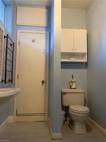 Bathroom featuring toilet and light wood finished floors